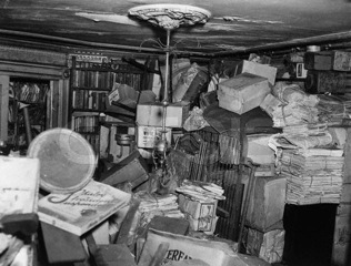 bundles of newspapers stacked to the ceiling